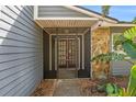 Inviting screened front porch with stone accents offering a charming entrance to the home at 1366 Wexford N Dr, Palm Harbor, FL 34683