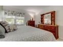 Comfortable bedroom with a soft color palette, wood furnishings, and a bright window view at 14130 Rosemary Ln # 1201, Largo, FL 33774