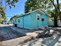 Rear view of a turquoise house featuring a spacious driveway at 1504 E 33Rd Ave, Tampa, FL 33610