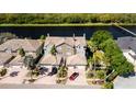 Gorgeous aerial view of a townhome with beautiful tile roof, garage and canal front location with mature landscaping at 1806 Lago Vista Blvd, Palm Harbor, FL 34685