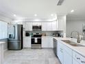 Bright kitchen featuring new stainless steel appliances, white cabinets, updated countertops, and backsplash at 19029 Us Highway 19 N # 27A, Clearwater, FL 33764