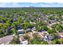 Expansive aerial view of a neighborhood with lush green trees, showcasing proximity to the city skyline at 1908 E Mcberry St, Tampa, FL 33610