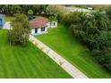 Aerial view showcasing a long driveway bordered by palm trees, leading to a charming home at 20 2Nd Se Ave, Lutz, FL 33549