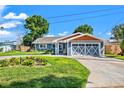 Lovely blue home with a well-manicured lawn, beautiful landscaping, and garage with striking white trim at 292 Sunlit Cove Ne Dr, St Petersburg, FL 33702