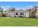 Charming single-story home with a well-manicured front lawn and tropical landscaping at 3256 Roxborough Ave, Clearwater, FL 33762