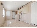 Well-lit laundry area with tile flooring, upper cabinets, and utility sink with easy access to the back door at 3256 Roxborough Ave, Clearwater, FL 33762
