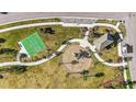 Aerial view of a playground featuring a basketball court, pavilion, and play equipment at 34024 White Fountain Ct, Wesley Chapel, FL 33545