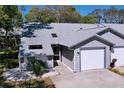 Inviting gray home with attached garage, mature trees, and landscaping at 39650 Us Highway 19 N # 411, Tarpon Springs, FL 34689