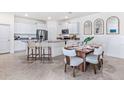 Modern kitchen with white cabinetry, stainless steel appliances, and a breakfast bar with a dining area at 4052 Westwood Fields Loop, Plant City, FL 33565