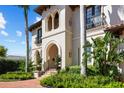 Detailed view of the home's entrance, showcasing the arched doorway, decorative columns, and lush green landscaping at 44 Martinique Ave, Tampa, FL 33606