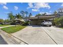 Convenient carport parking with well-maintained landscaping adding to the property's curb appeal at 440 Woods Landing Trl, Oldsmar, FL 34677