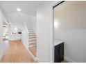 Bright foyer featuring hardwood floors, white staircase and convenient powder room at 5011 S Elberon St, Tampa, FL 33611