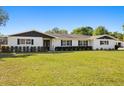 Charming painted brick home featuring dark shutters and manicured landscaping at 5305 Coronet Rd, Plant City, FL 33566