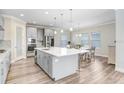 Well-lit kitchen featuring an island with bar seating, stainless steel appliances, and stylish gray cabinetry at 5407 Tagalong Pl, Apollo Beach, FL 33572