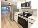 Modern kitchen with stainless steel appliances, white cabinets, and tile backsplash at 5880 38Th N Ave # 107, St Petersburg, FL 33710