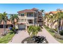 Stunning waterfront home boasts lush landscaping, a circular driveway, and a terracotta roof at 700 126Th Ave, Treasure Island, FL 33706