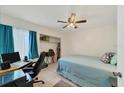 Cozy bedroom featuring a comfortable bed, a ceiling fan, and a closet for storage at 9150 Arrid Cir, Port Charlotte, FL 33981