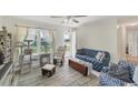 Inviting living room with neutral walls and tile flooring, comfortable seating and a sunlit window at 9150 Arrid Cir, Port Charlotte, FL 33981