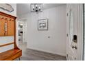 Bright foyer featuring stylish light fixture, wood-look floors, coat rack and view into a bedroom at 12299 91St N Ave, Seminole, FL 33772