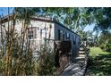 Exterior view of home with wooden deck, greenery, light beige siding, and a natural green lawn at 12720 Four Oaks Rd, Tampa, FL 33624