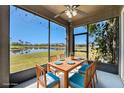 Screened lanai offering stunning lake views and providing comfortable outdoor dining space at 13820 Chalk Hill Pl, Riverview, FL 33579