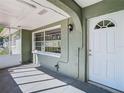 Inviting covered porch featuring textured walls and light fixtures near the arched front door at 15536 George Blvd, Clearwater, FL 33760