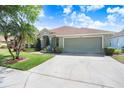 A well-maintained one-story home with an attached garage and a long driveway for parking at 16843 Harrierridge Pl, Lithia, FL 33547