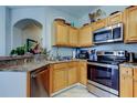 Functional kitchen featuring stainless steel appliances and light wood cabinets at 17965 Villa Creek Dr, Tampa, FL 33647