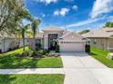 Charming single-story home with a well-maintained lawn and colorful landscaping at 20352 Falling Rock Dr, Land O Lakes, FL 34638