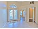 Bright foyer with decorative glass double doors, tile flooring, and arched transom window at 3217 Partridge Point Trl, Valrico, FL 33596