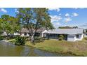 Peaceful backyard featuring a screened-in porch and a tranquil waterfront view at 3553 Delta Pl, Holiday, FL 34691