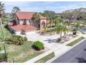 Expansive property showcasing a red-roofed home, a water fountain, a long driveway, and mature trees at 4404 Lake In The Woods Dr, Spring Hill, FL 34607