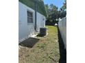 Exterior view of the side of the house, featuring an AC unit and a white fence at 6406 Stone Rd, Port Richey, FL 34668