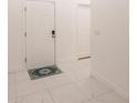 Bright hallway with a decorative welcome rug on top of white tile flooring at 733 Garden Oaks Sq, Seffner, FL 33584