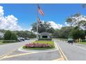 Community entrance featuring an American flag and guard house, for active adult living at 7472 Clearmeadow Dr, Spring Hill, FL 34606