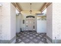 Inviting entryway featuring tiled flooring, a decorative front door, and stylish light fixture at 7472 Clearmeadow Dr, Spring Hill, FL 34606