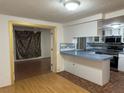 An open-concept kitchen with white cabinets and blue countertops at 9741 Scenic Dr, Port Richey, FL 34668