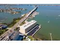 Aerial view of a waterfront apartment building complex near the bridge with parking and docks at 100 Bluff View Dr # 409C, Belleair Bluffs, FL 33770