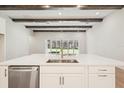 Modern kitchen featuring an island, stainless steel dishwasher, white cabinets, and wood beam ceiling at 12817 Daleridge Pl, Riverview, FL 33579