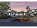 Charming single-story home with manicured yard and exterior lighting at dusk, creating an inviting ambiance at 129 94Th Ave, Treasure Island, FL 33706