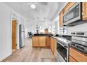 Open kitchen with stainless steel appliances, light wood cabinets, and a view into the adjacent living area at 129 94Th Ave, Treasure Island, FL 33706
