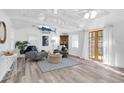 Bright living room with vaulted ceilings, neutral decor, and French doors leading to the outside at 129 94Th Ave, Treasure Island, FL 33706