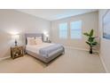 Comfortable bedroom featuring a neutral color scheme, a plush bed, and natural light from the windows at 34329 Evergreen Hill Ct, Wesley Chapel, FL 33545