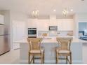 Modern kitchen featuring white cabinets, stainless steel appliances, and an island with bar seating at 34329 Evergreen Hill Ct, Wesley Chapel, FL 33545