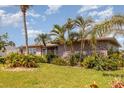 Well-maintained home featuring lush landscaping and unique stone accents at 4 Oakland Hills Ct, Rotonda West, FL 33947