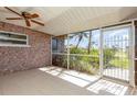 Enclosed lanai with tile flooring, ceiling fan, and serene backyard view at 4 Oakland Hills Ct, Rotonda West, FL 33947