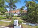 Beautiful home with a well-manicured lawn, mature landscaping, and a unique mailbox at 441 Village Dr, Tarpon Springs, FL 34689