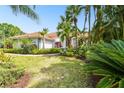 Gorgeous home featuring lush landscaping, a red tile roof, and a well-manicured lawn at 441 Village Dr, Tarpon Springs, FL 34689
