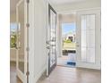 Inviting foyer showcasing a glass-paneled front door and light tile flooring at 5335 Wolf Creek Dr, Apollo Beach, FL 33572