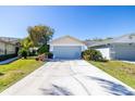 Exterior view of home featuring a gray garage door and a long paved driveway at 6018 Gentle Ben Cir, Wesley Chapel, FL 33544
